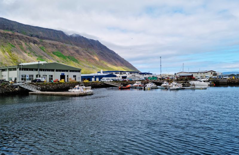 Pittoreske haven in IJsland, met boten en steile bergen op de achtergrond