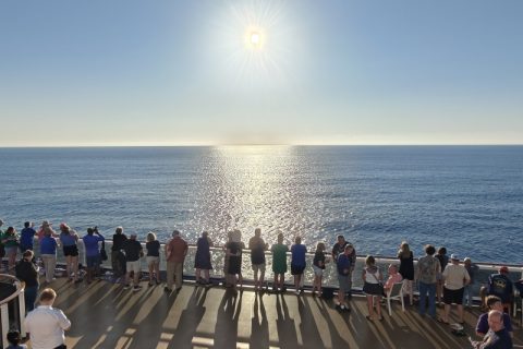 Gasten aan boord van de Carnival Legend bekijken de zonsverduistering